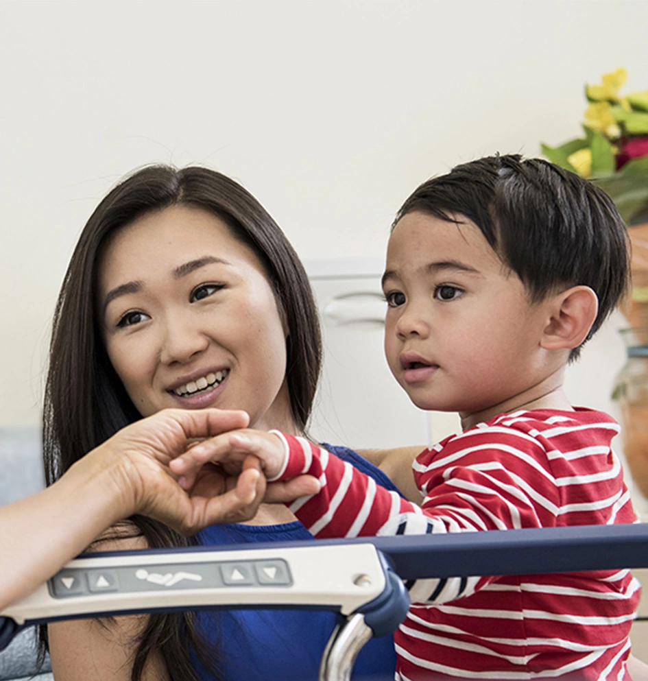 Grandson holding grandmothers hand at hospital